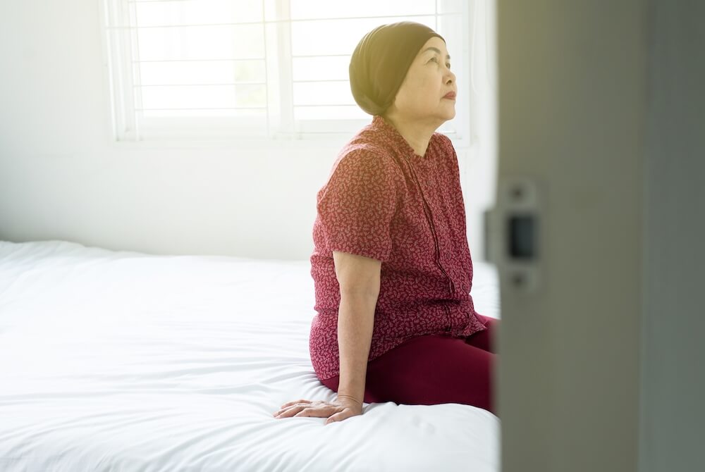 senior-asian-woman-with-disease-cancer-sitting-in-her-bedroom-elderly-female-feeling-depressed-and_t20_Ozy00y